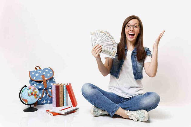 Young excited student holding scholarship money